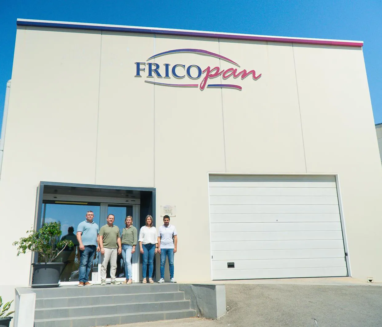Edificio principal de Fricopan con un grupo de personas al frente
